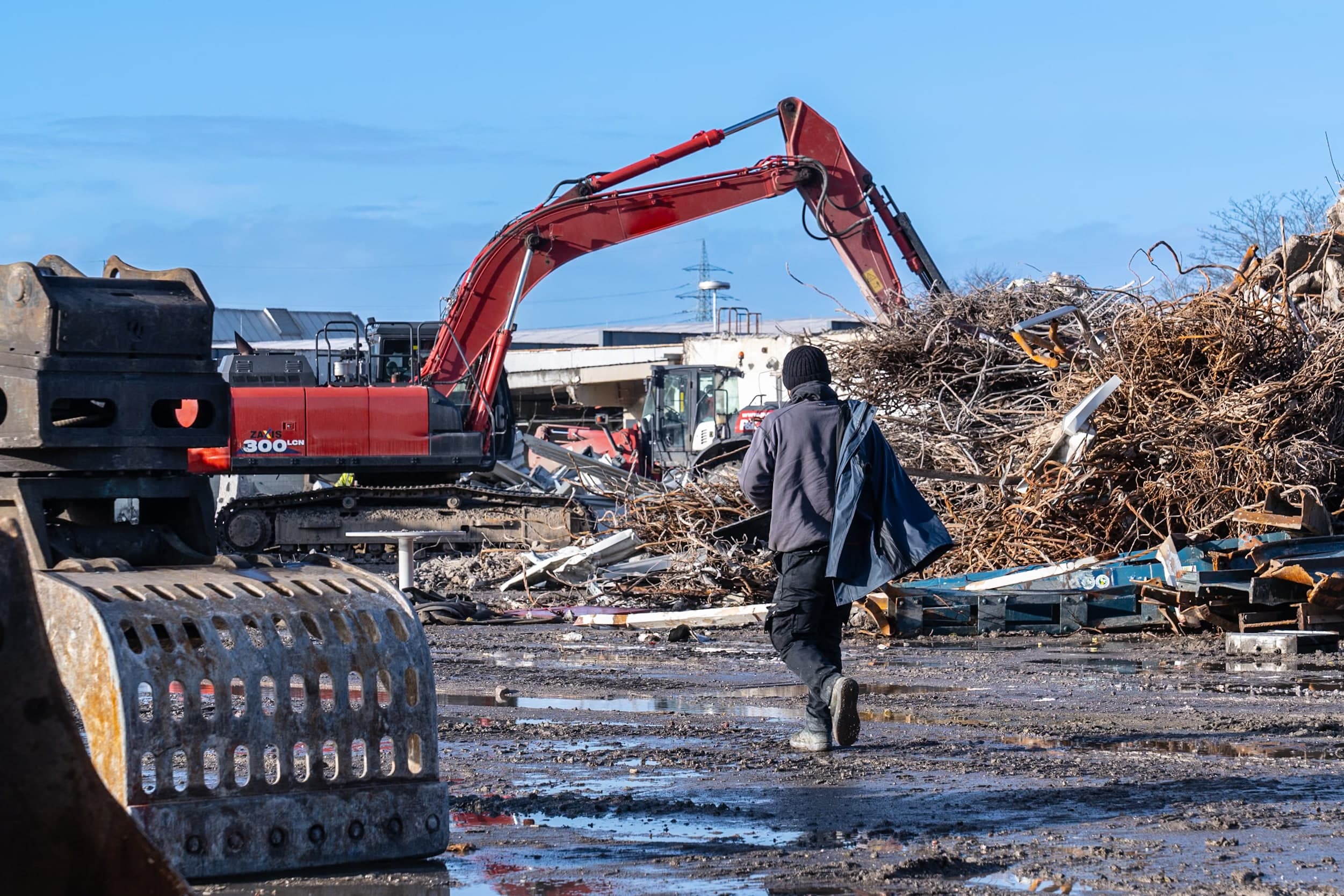 Person und Bagger auf einer Abbruchbaustelle