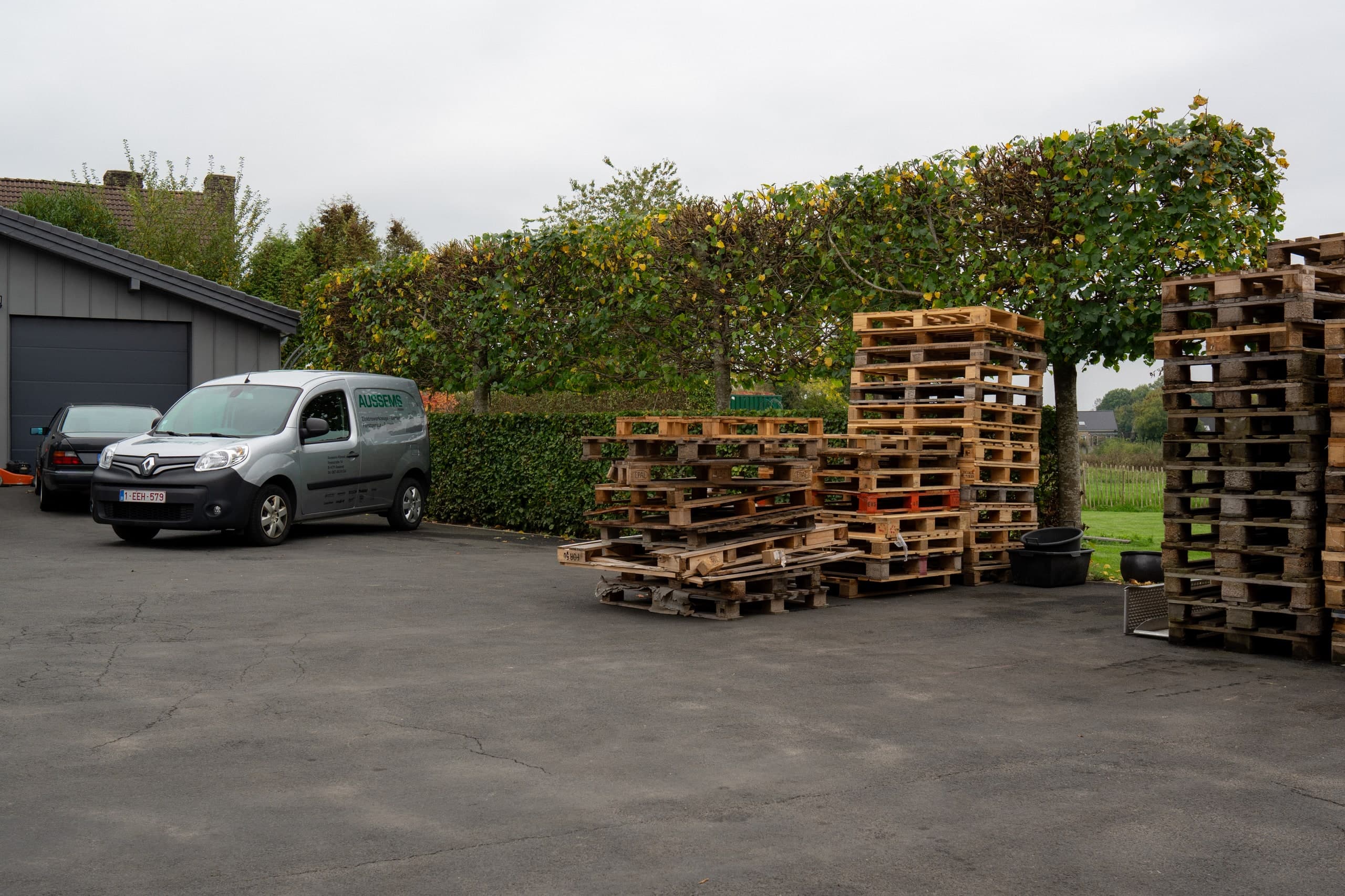 Transportfahrzeug neben gestapelten Holzpaletten