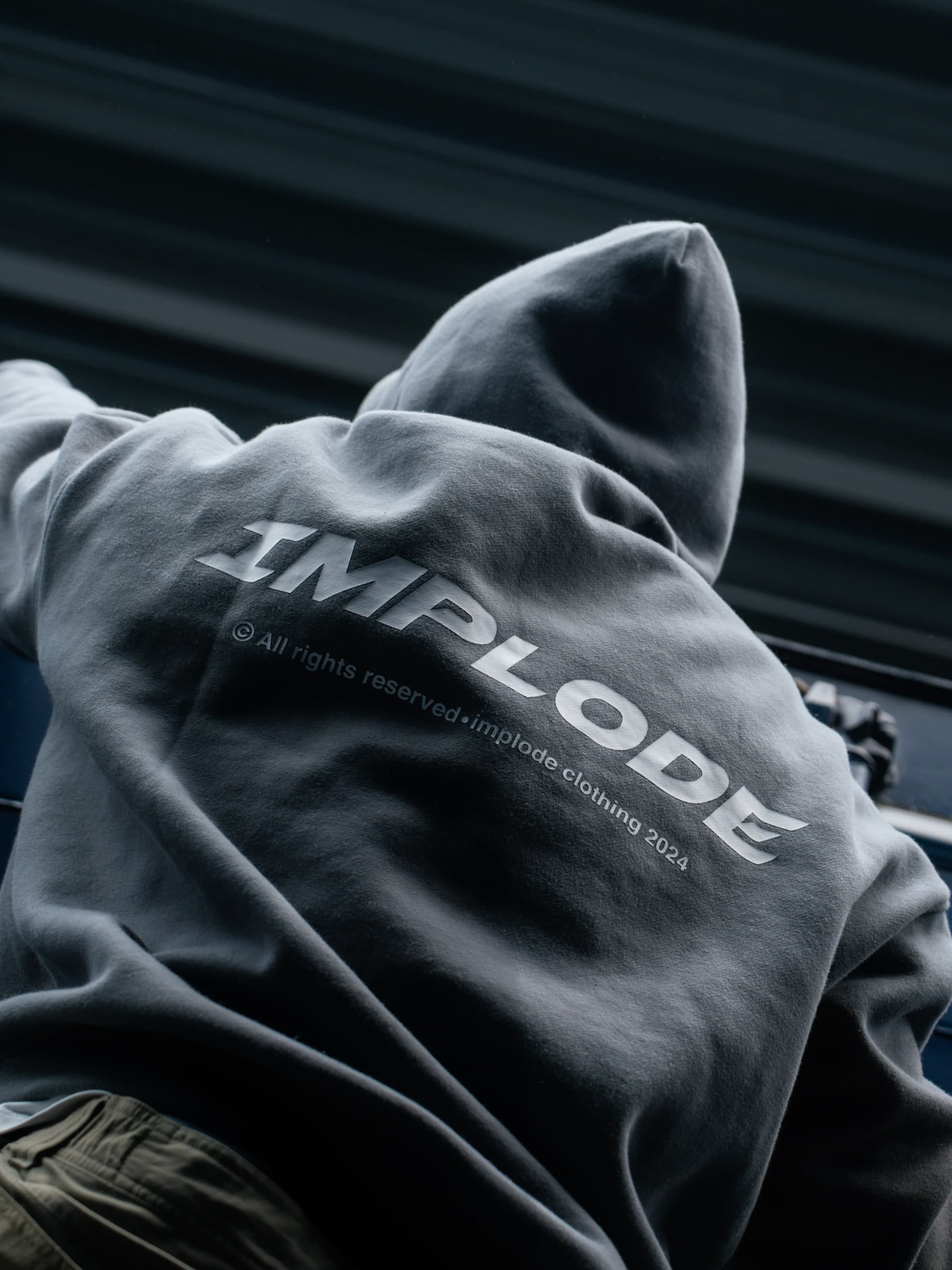 Detail eines grauen Sweatshirts mit aufgedrucktem Schriftzug