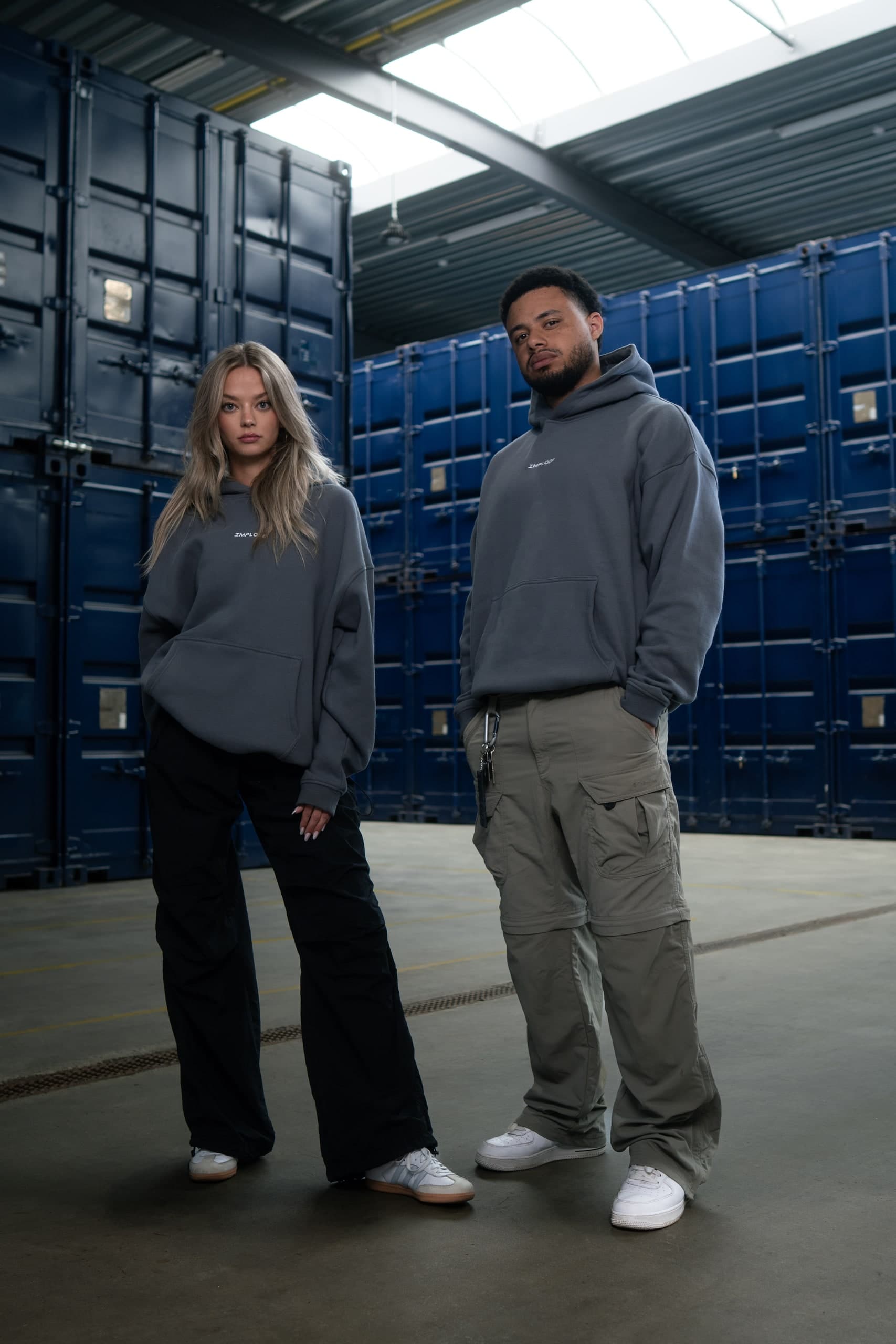 Zwei Personen in grauen Sweatshirts in einer Halle