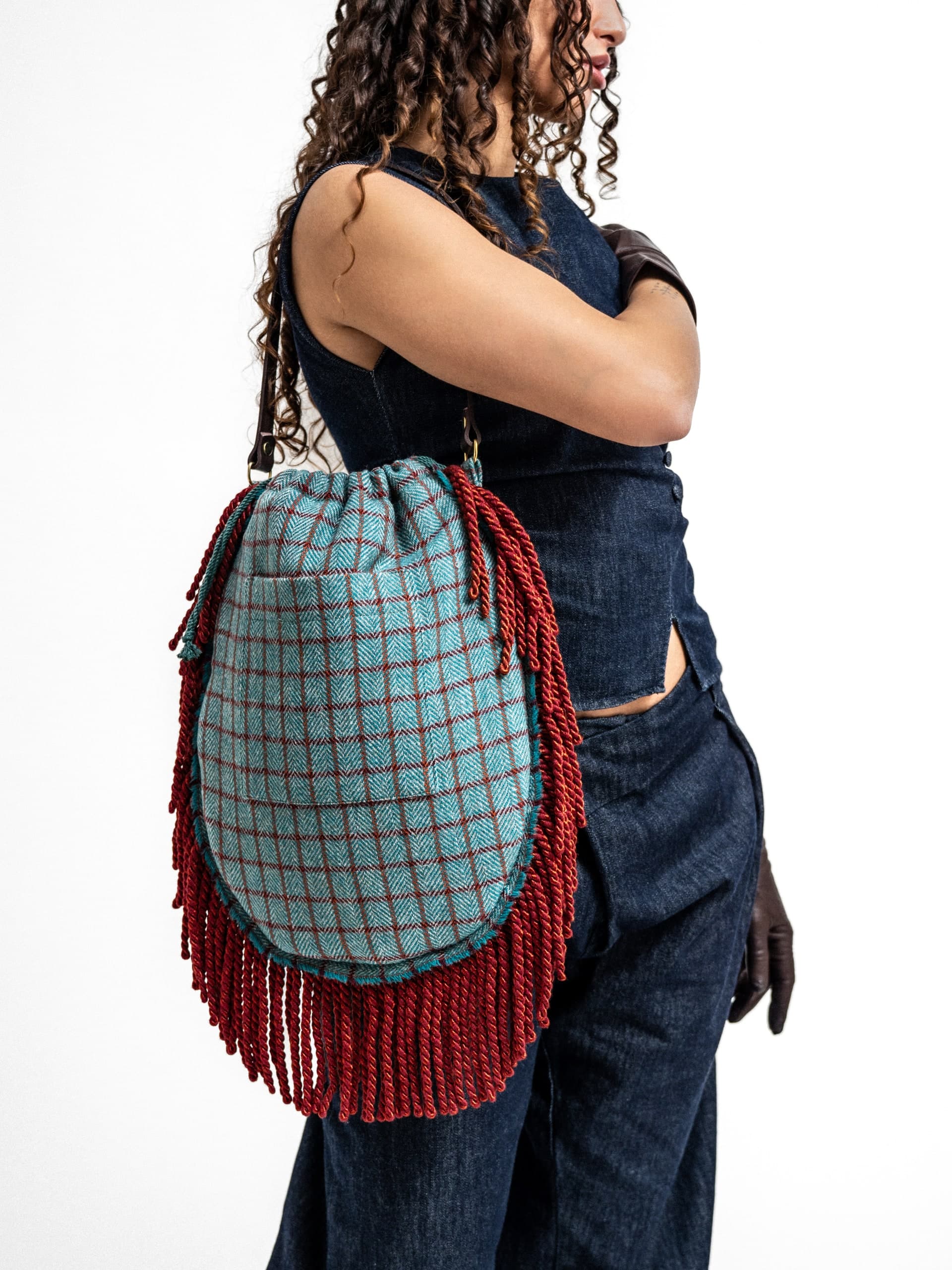 Model mit blau karierter Tasche vor weißem Hintergrund