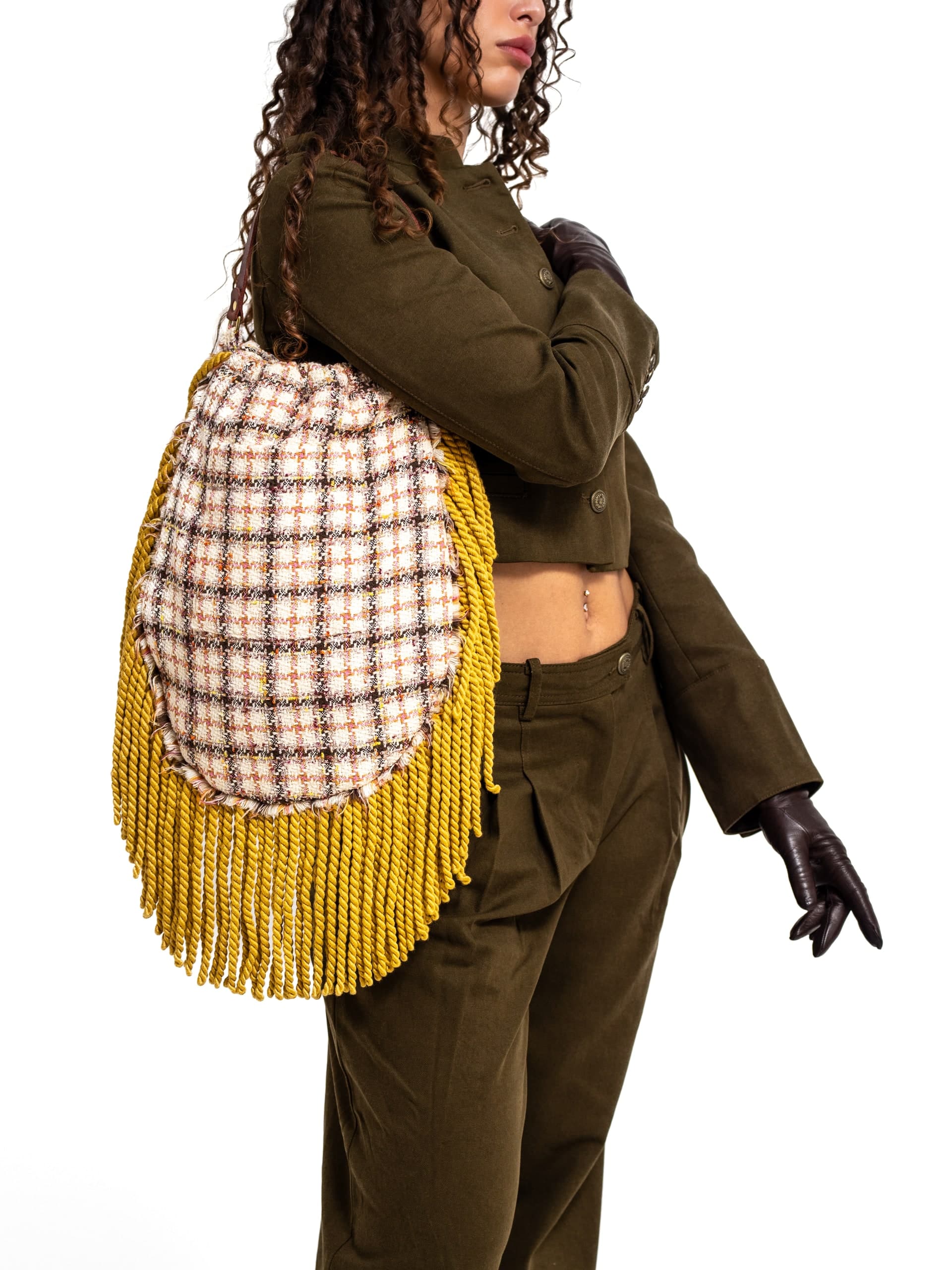 Model mit gelb karierter Tasche vor weißem Hintergrund