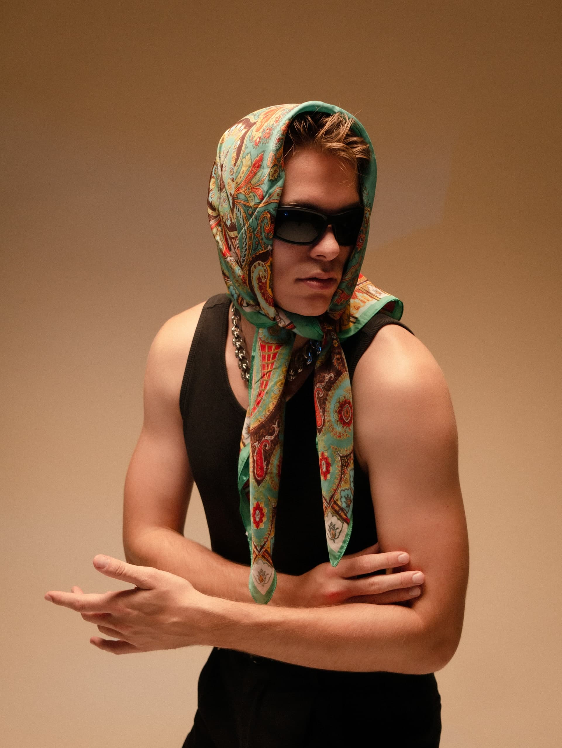 Mann mit Sonnenbrille vor warm beleuchtetem Hintergrund