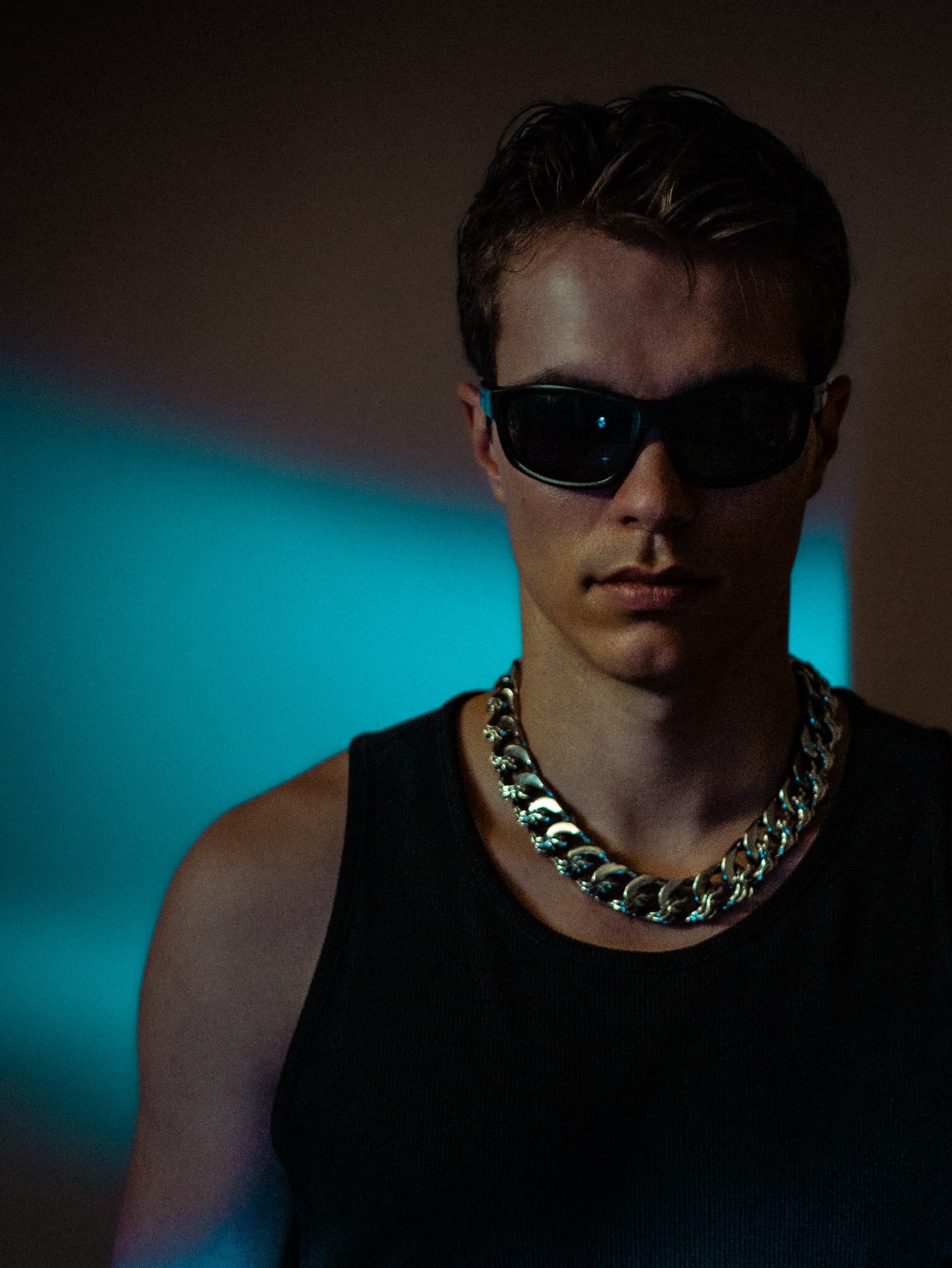 Porträt eines Mannes mit Sonnenbrille vor blauem Licht