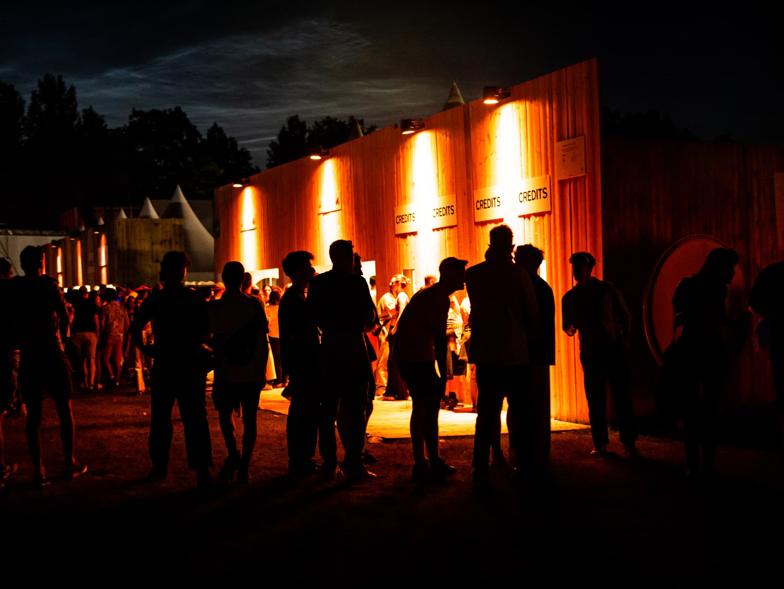 Silhouetten vor einer warm beleuchteten Installation