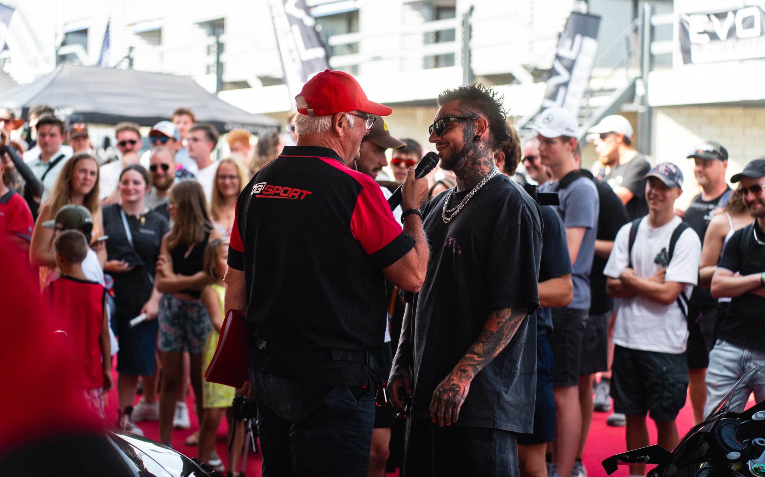 Menschen im Gespräch auf einer Motorsportveranstaltung