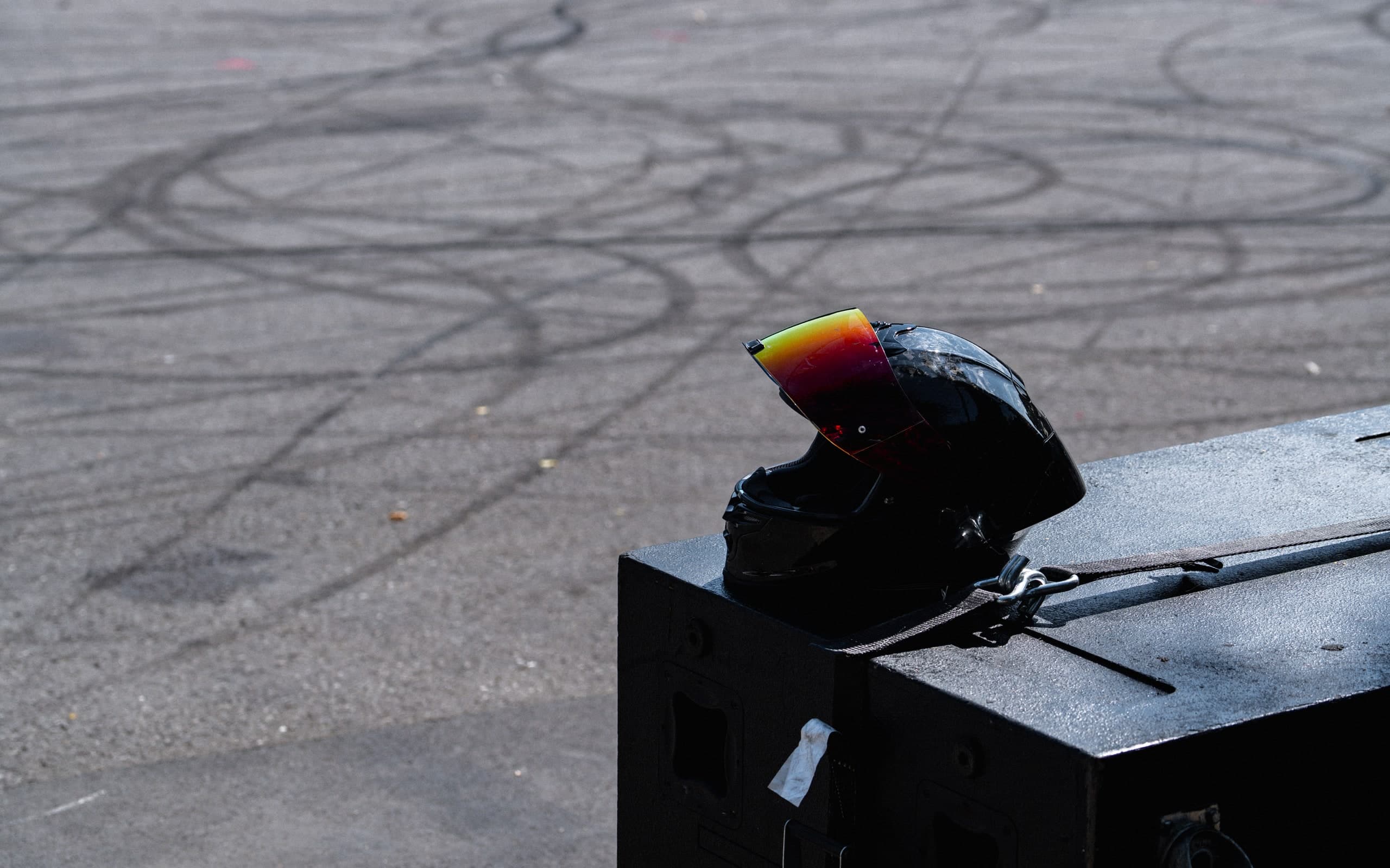 Helm auf einer Absperrung vor Reifenspuren