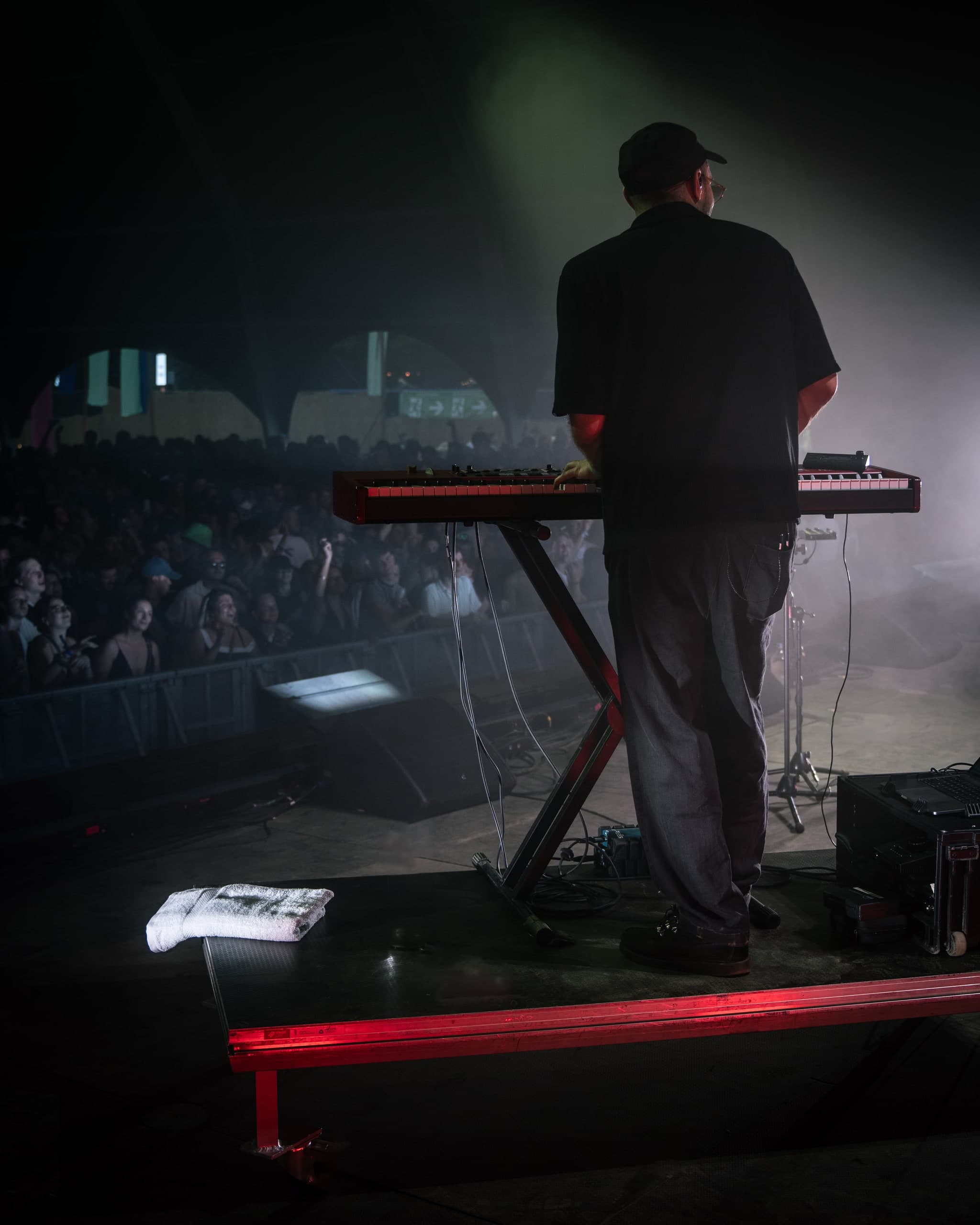 Musiker am Keyboard auf einer dunklen Bühne